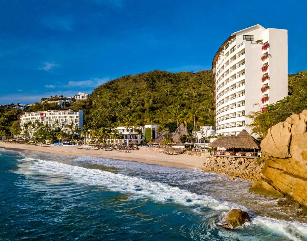 waves crashing against white sand by luxury hotel puerto vallarta mexico