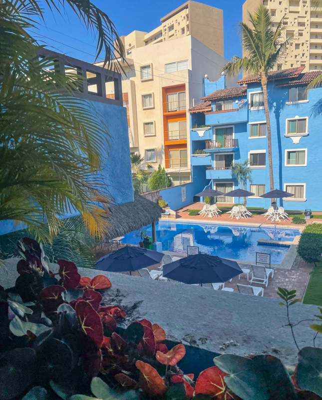 An outdoor pool located next to a blue building, providing a tranquil oasis for swimming and relaxation.