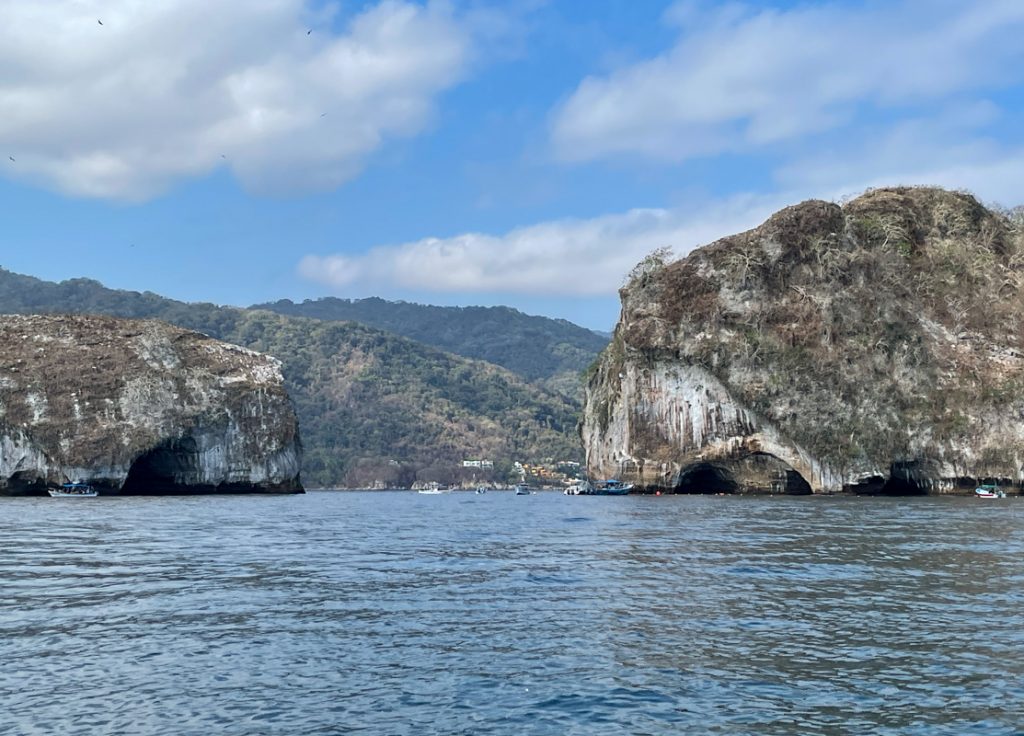 rock formations sticking out of the pacific ocean at Los Arcos National Marine Park in puerto vallarta mexico.