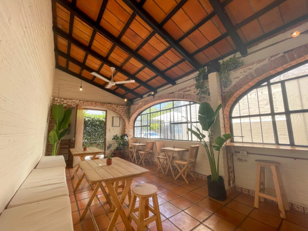 wooden chairs and tables with plants inside Miscelanea Puerto Vallarta