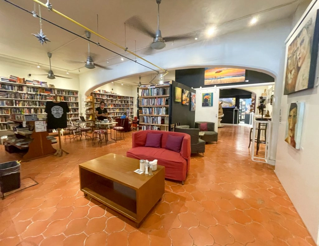 interior of el sofa cafe, featuring bookcases filled with books and a cozy red sofa, perfect for relaxation and enjoying your favorite cup of coffee.