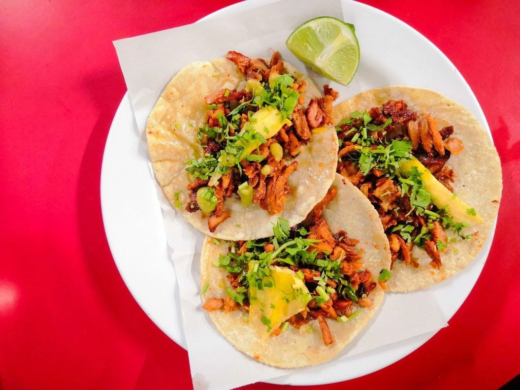 three tacos on a red table in mexico