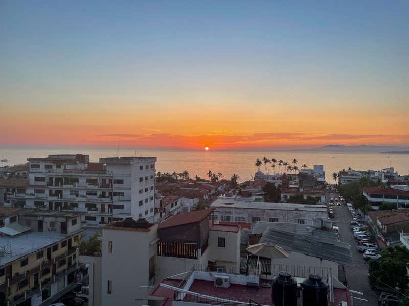 sunset over the city of puerto vallarta from a restaurant terrace
