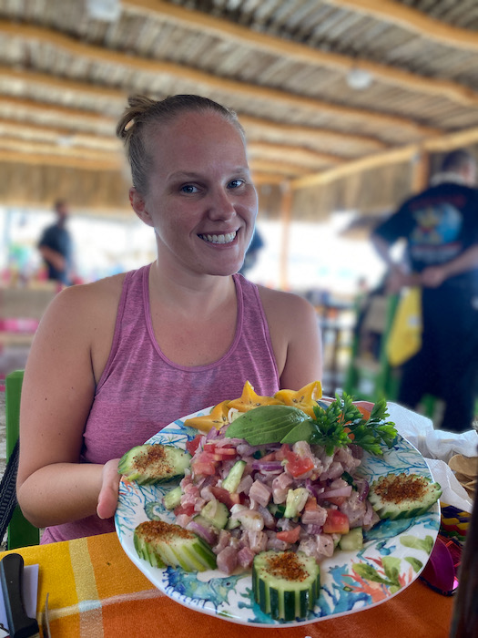 girl holding a plate of ceviche while smiling in bucerias mexico
