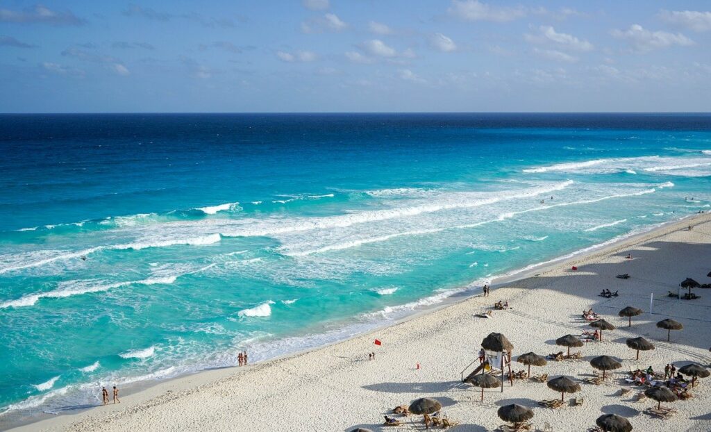 turquoise waves gently rolling into a white beach in cancun