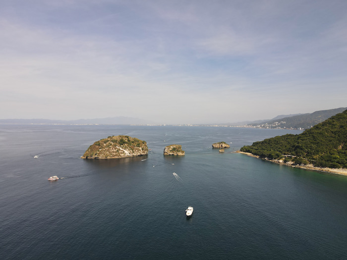 aerial view of boats going by Los Arcos rocks in Puerto Vallarta mexico