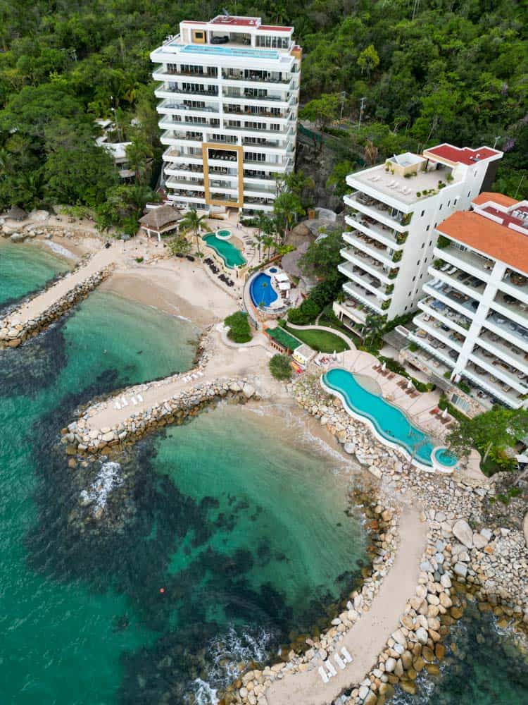 drone shot of xalli beach club with emeral green water