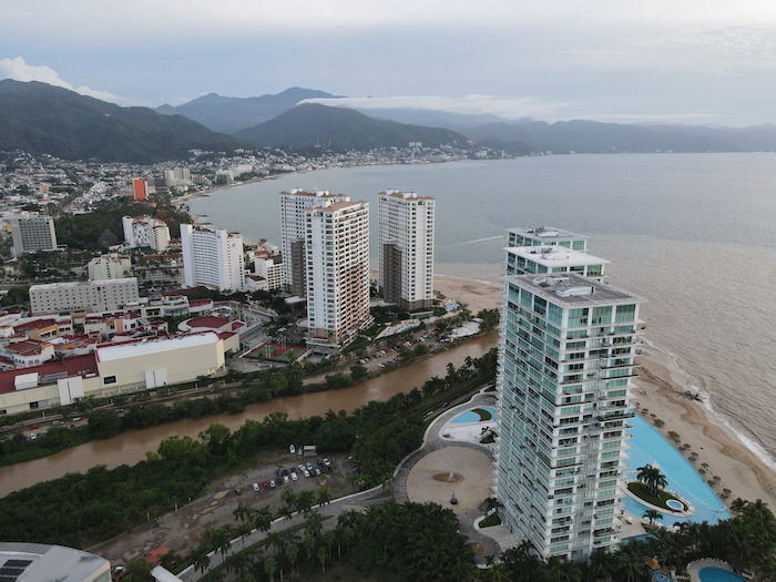 An aerial view of a beach and buildings near the ocean.