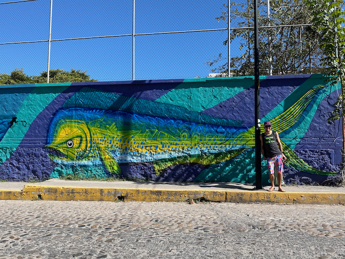 sasha standing by Puerto Vallarta street art in 5 de diciembre
