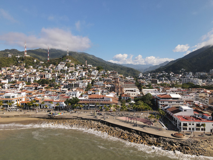 aerial shot of El Centro in Puerto Vallarta. beach with city and rolling hills in backdrop.
