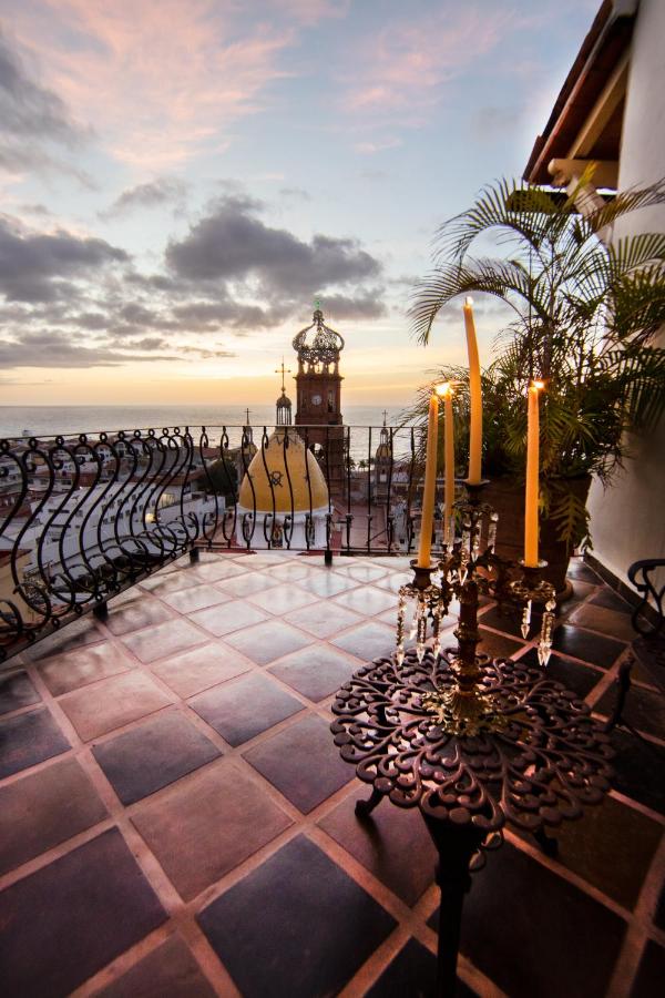 Chic terrace at Hotel Bellview, adorned with comfortable lounge furniture and potted plants, overlooking the iconic church and bustling streets of Puerto Vallarta, providing a perfect spot for relaxation and contemplatio