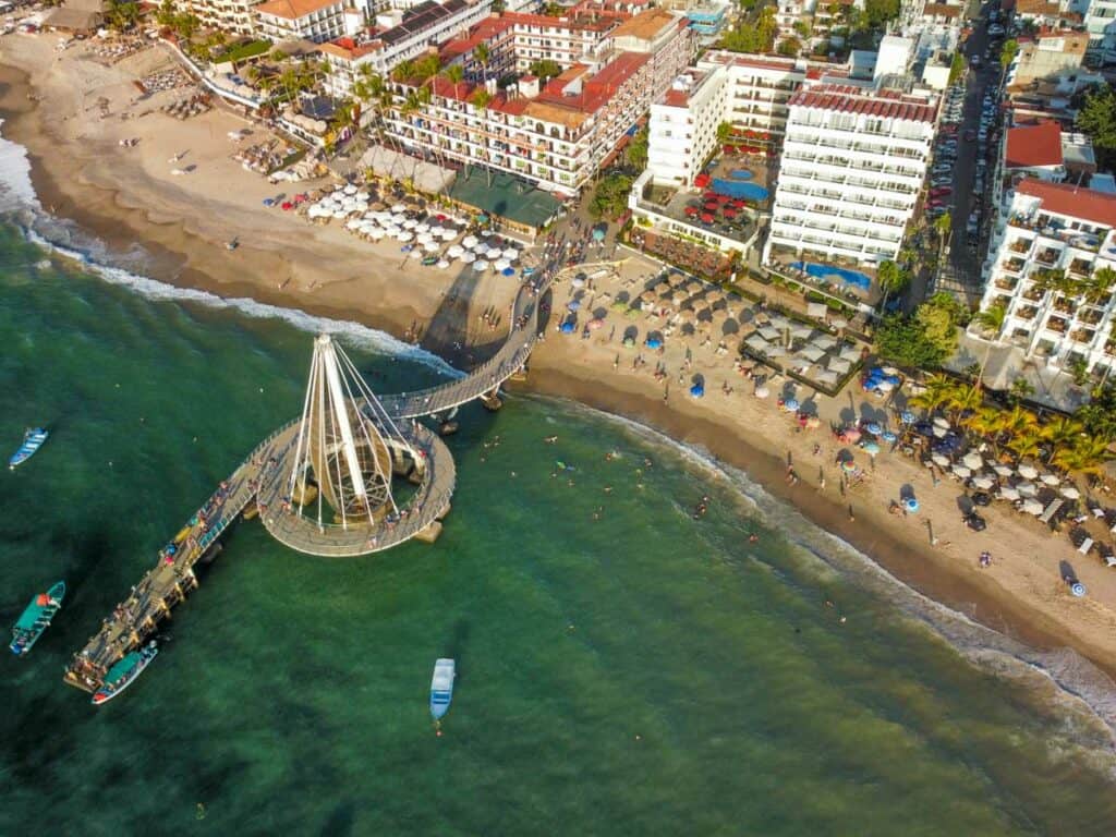 drone shot of los muertos pier from above. behind it is los muertos beach