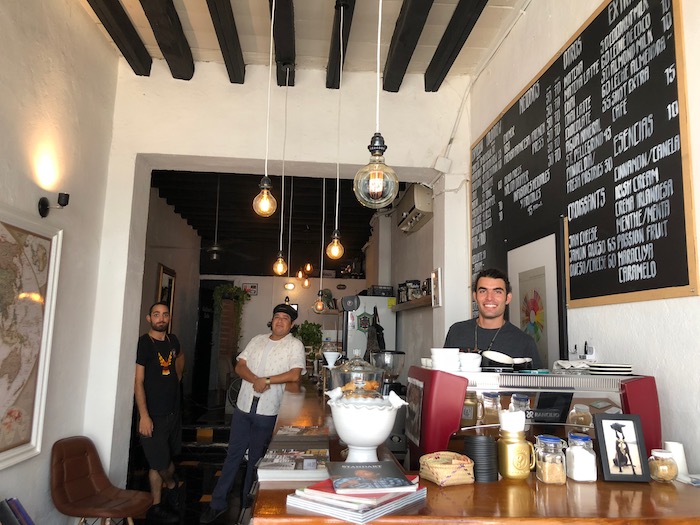  A friendly barista with a warm smile expertly prepares a cup of coffee inside Puerto Cafe