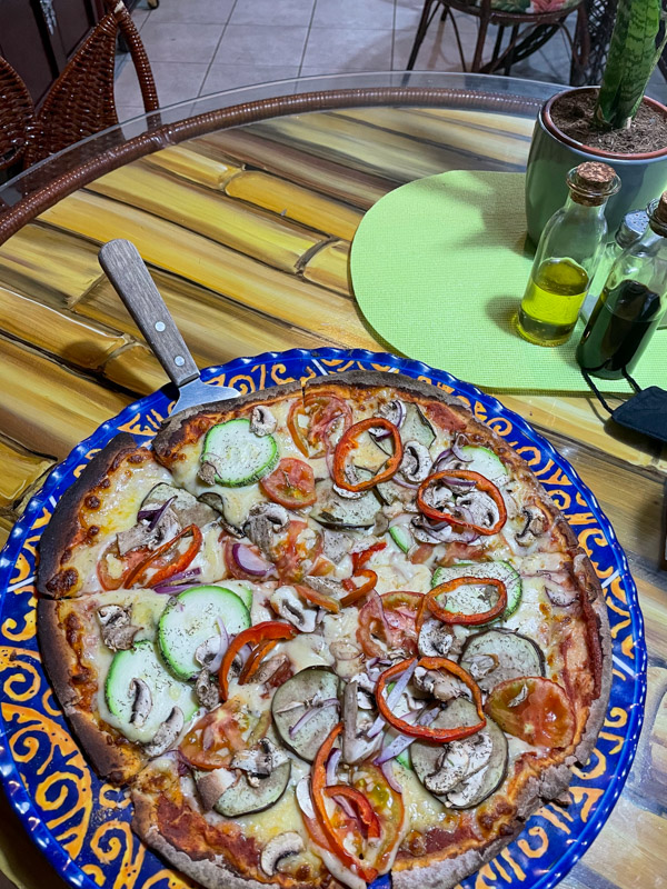 colorful pizza with peppers, eggplant, and zucchini on a mexican dish