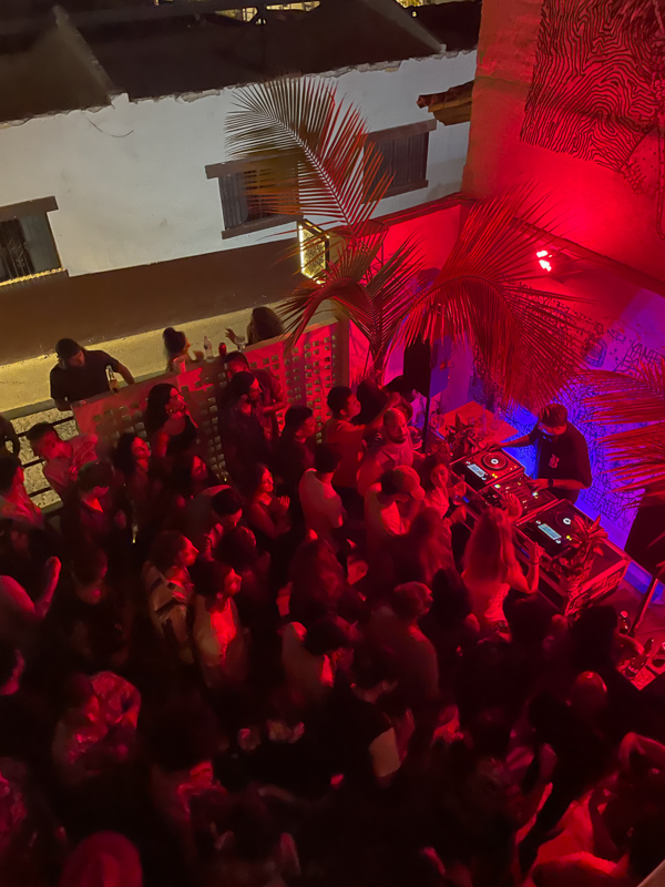 mage capturing the lively atmosphere of a club in Puerto Vallarta, Mexico, with people dancing, enjoying the music, and vibrant lights illuminating the energetic crowd