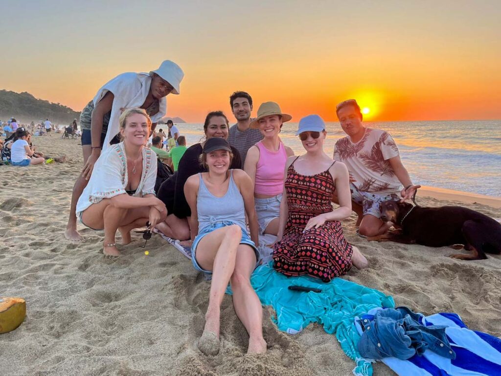 group of friends on the beach in san pancho mexico with sunset in background