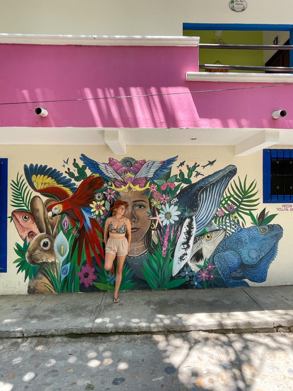 Lora strikes a pose against a vibrant art mural in Yelapa, 