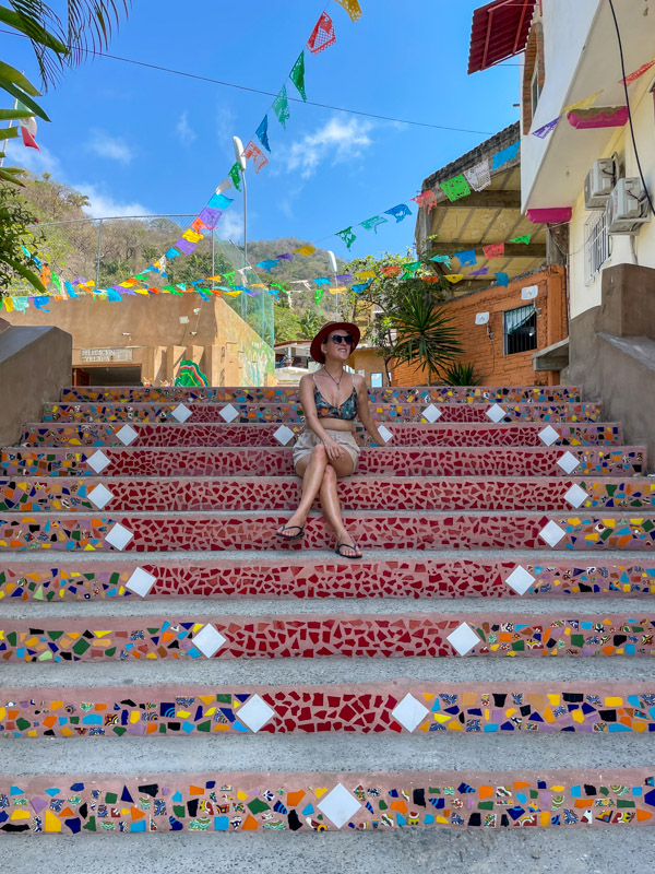 lora sitting on colorful stairs in yelapa
