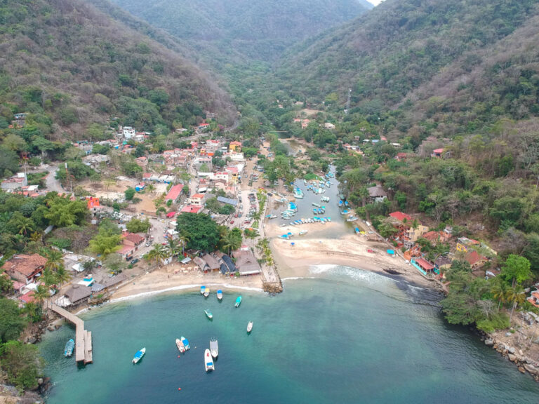 aerial photo of boca de tomatlan. shows boats in ocean docks at the beach.