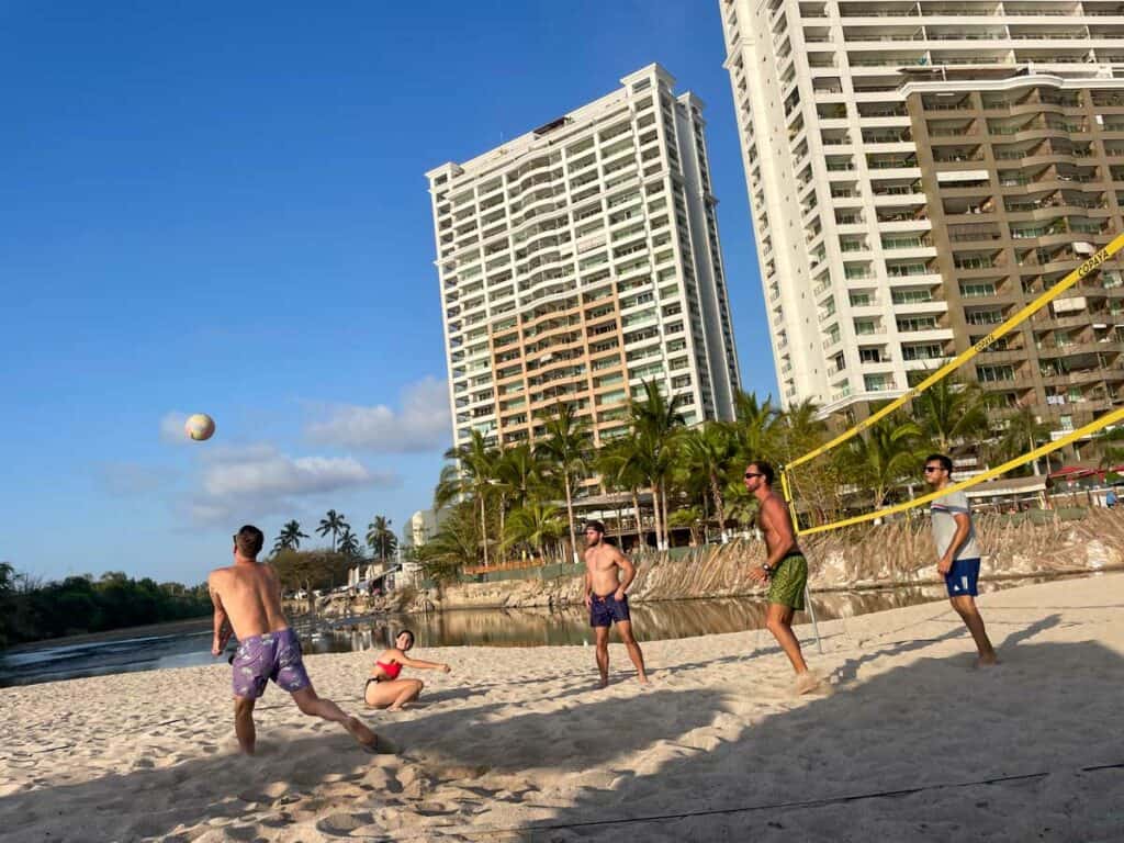 a group of expats in puerto vallarta play volleyball on the beach