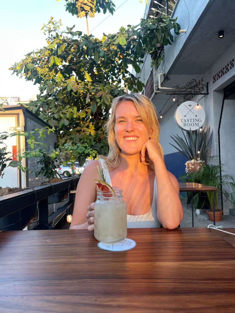 lora drinking a cocktail on the terrace of el tasting room in puerto vallarta