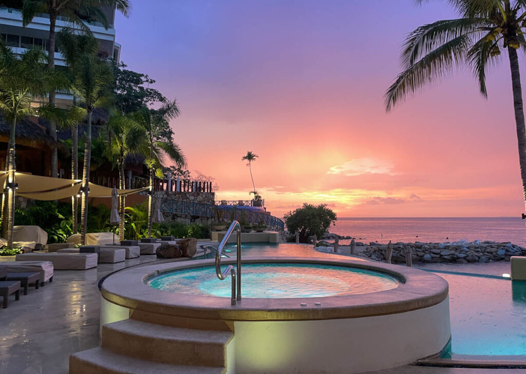 hot tub facing a pink and purple sunset in puerto vallarta