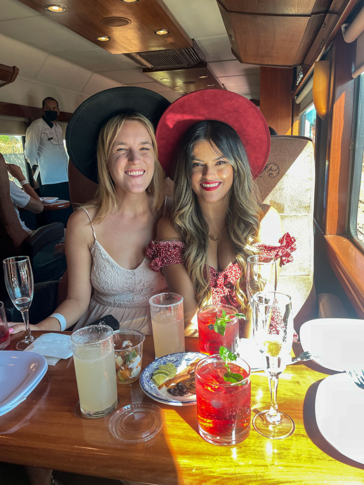 lora and friend on a train in mexico drinking tequila and smiling