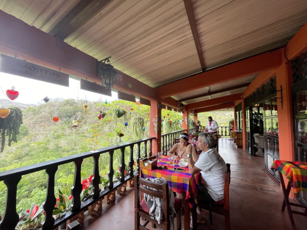 people in restaurant overlooking mountains