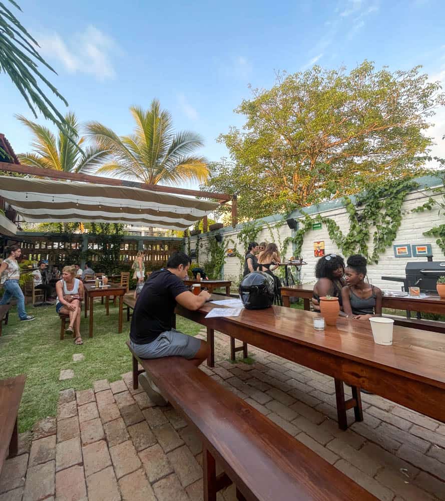 People socializing and enjoying drinks at an inviting outdoor bar, soaking in the energetic ambiance.