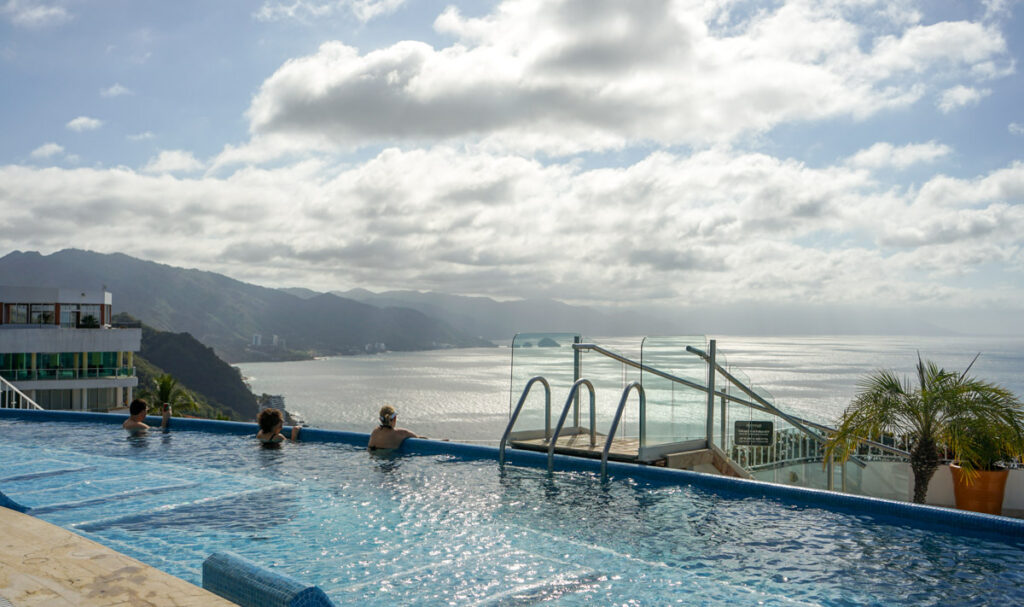 two people in the rooftop pool at the grand miramar puerto vallarta overlooking the mountains