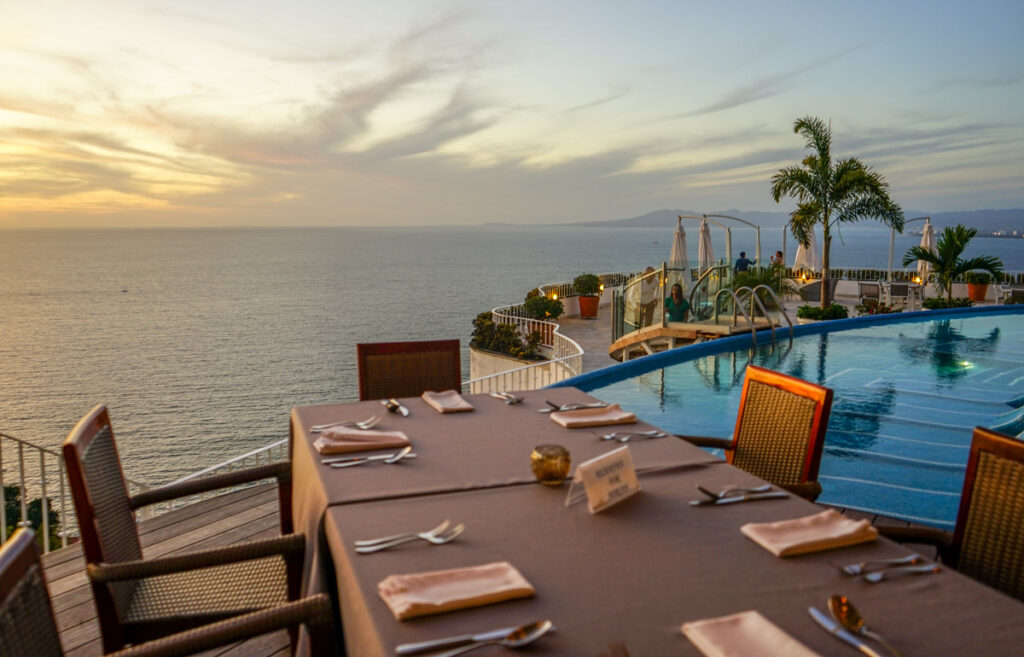 dining table at eugenia next to infinity pool at sunset in puerto vallarta