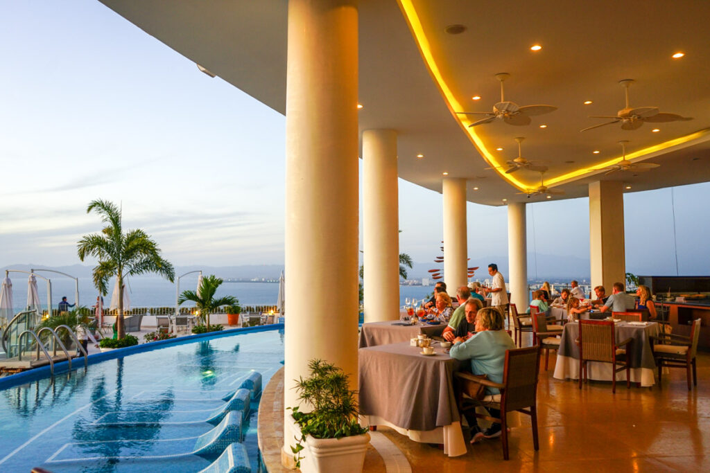 people dining at restaurant by infinity pool and ocean