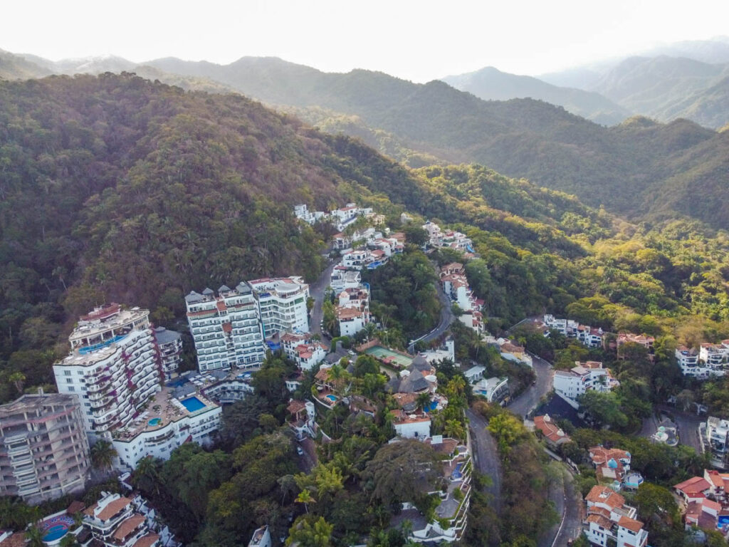 aerial view of rolling green hills in puerto vallarta with houses on them