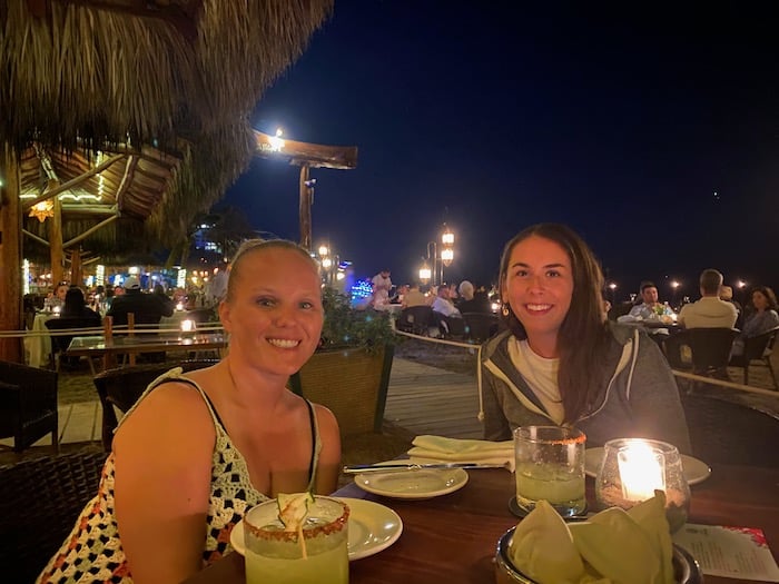 two close friends enjoy a delightful dining experience at La Palapa, an iconic beachfront restaurant in Puerto Vallarta. 