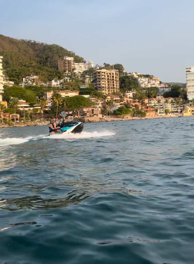 Two people enjoying a thrilling ride on a jet ski in the sparkling blue waters of Puerto Vallarta.