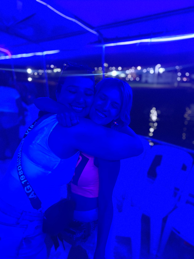 two girls hugging on the neon boat party in puerto vallarta