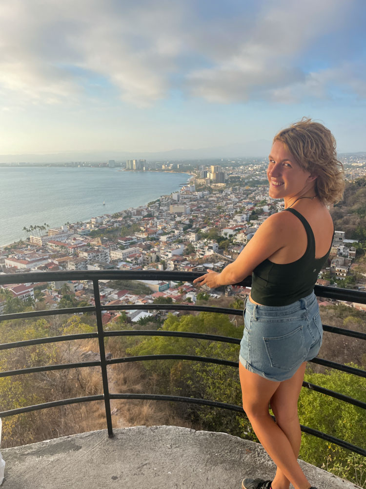 A woman overlooking a city, capturing one of Puerto Vallarta's Instagram spots.
