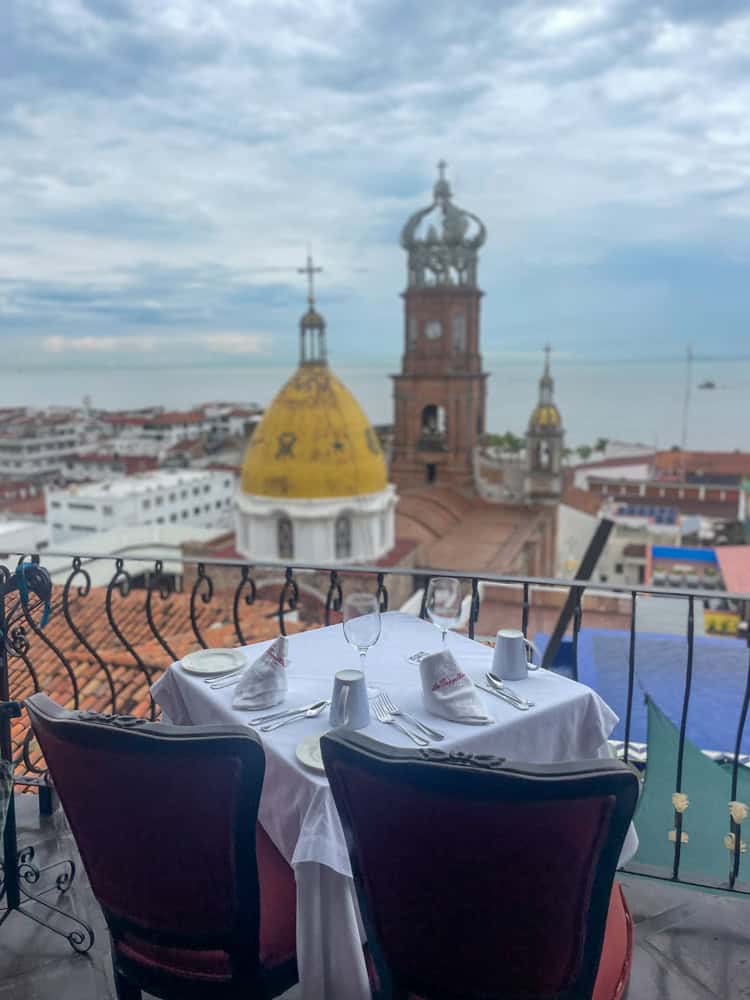 A balcony with a table and chairs, offering breathtaking views of Puerto Vallarta.