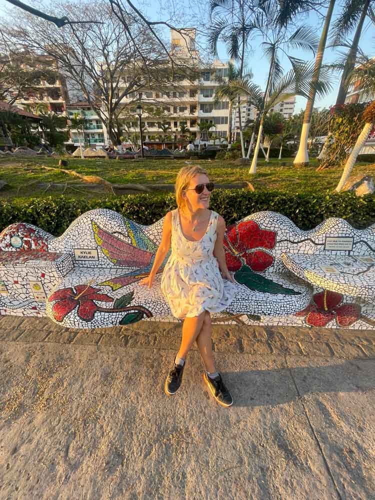 A woman sitting on a mosaic bench in Puerto Vallarta.